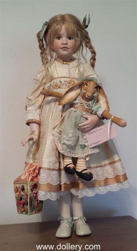 The Doll Is Holding A Teddy Bear And Wearing A Dress With Laces On It