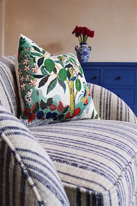 If you choose a variety of pillows in different patterns, the look will still be cohesive if they at least share the same colors. Blue Striped Armchair With Colorful Pillow | HGTV