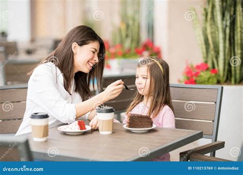 Mother Feeding Her Daughter With Cake At The Cafe Stock Image Image