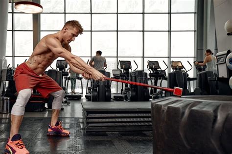 strength concept male athlete using hammer during fitness workout fitness man beating rubber