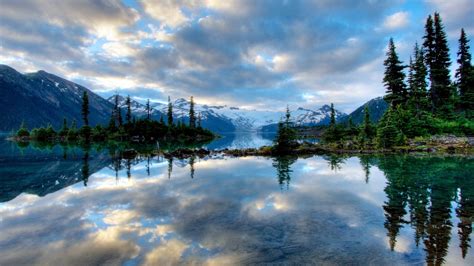 Landscape View Of Snow Covered Mountains With Reflection On Calm Body