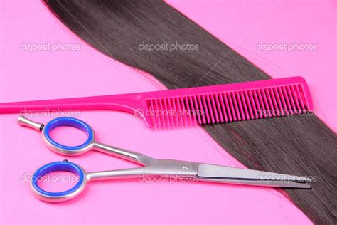 Long Black Hair With Comb And Scissors On Pink Background Stock Photo