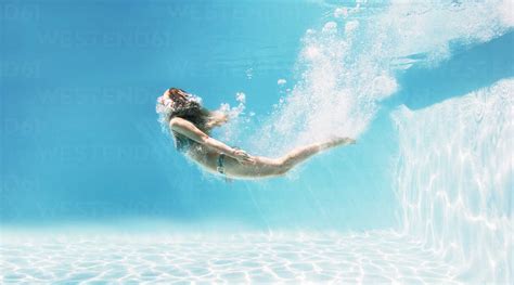 Woman Swimming Underwater In Swimming Pool Lizenzfreies Stockfoto