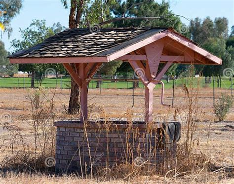 Decorative Brick Wishing Well With Shingle Covered Roof Stock Image
