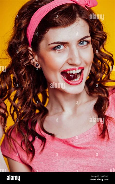 Beautiful Woman In Pink Keeps In Her Mouth Berry Stock Photo Alamy