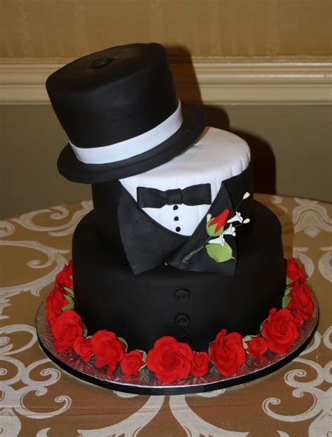 A Three Tiered Cake With A Top Hat And Bow Tie On Its Side