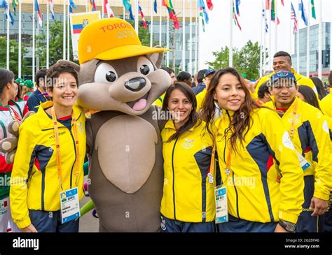 Athletes From Ecuador Posing For Photograph With The Mascot Pachi The