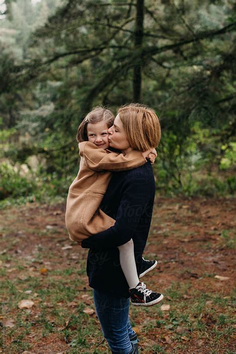 Mother Holding Young Daughter And Kissing Her On Cheek By Stocksy Contributor Leah Flores