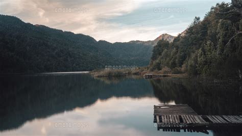 Scenic View Of Calm Lake Amidst Mountains Against Sky During Sunset