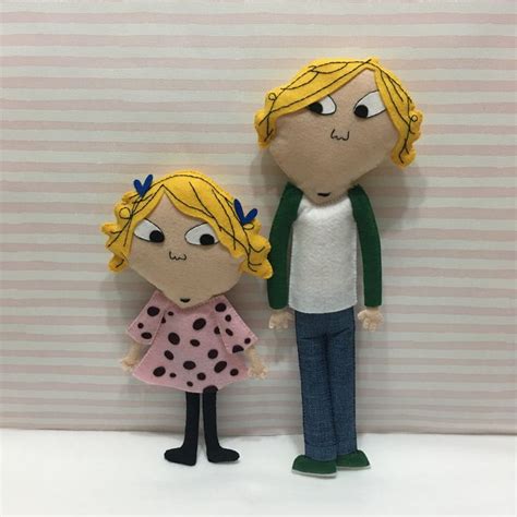 Two Dolls Standing Next To Each Other On A White Surface With Striped