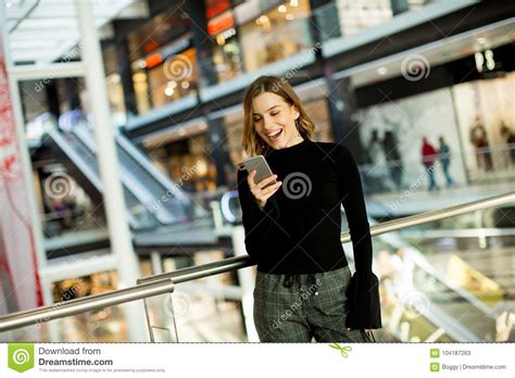 Lovely Young Woman Looking On Mobile Phone In Shopping Center Stock