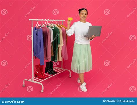 Happy Asian Fashionista Woman Holding Credit Card and Laptop Stock