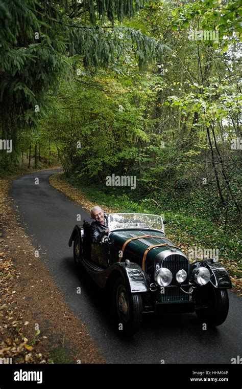 Senior Man Driving Down Country Road In Antique Car Stock Photo Alamy