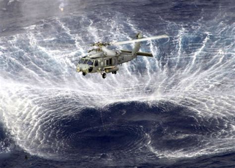 The Rotor Wash Of A Navy Sh 60f Seahawk Helicopter Kicks Up A Circle Of