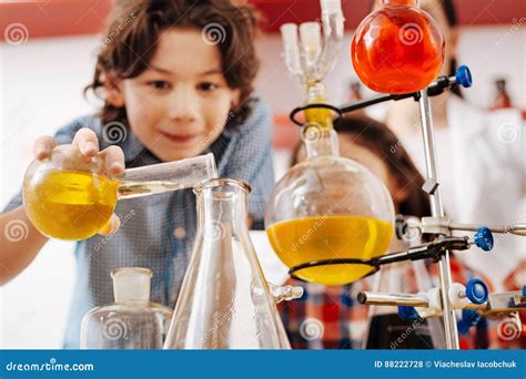 Selective Focus Of Chemical Flasks Being Held By A Boy Stock Photo