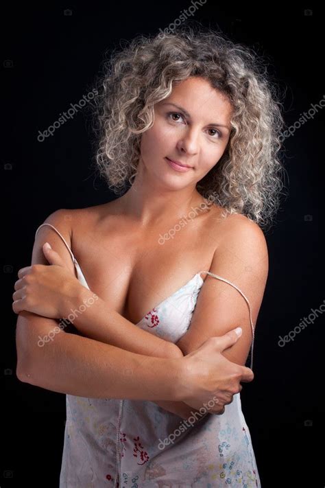 黒の背景にポーズのランジェリーを着て巻き毛の成熟した女性 ストック写真 evasilchenko