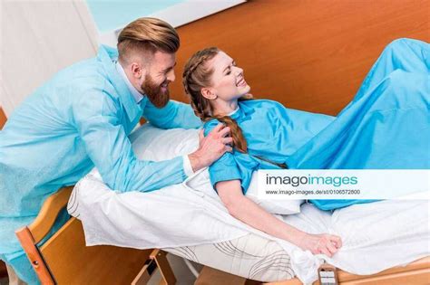 Pregnant Woman Giving Birth In Hospital While Man Hugging Her