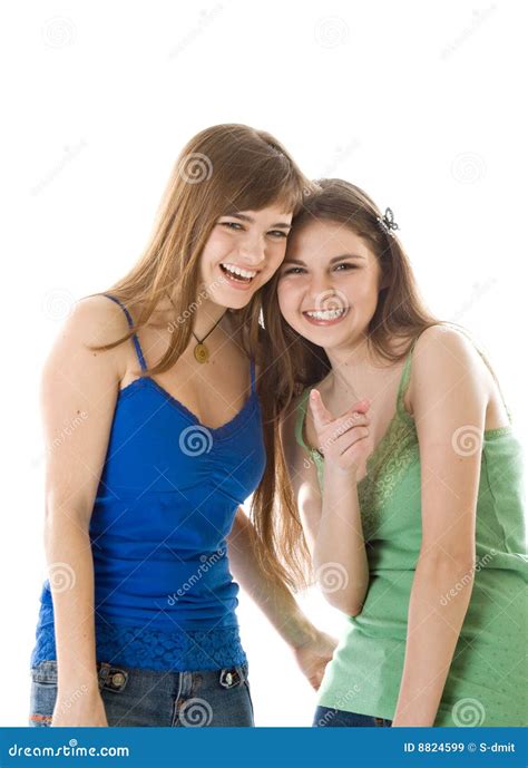 Two Teenage Girls In Headscarves Stretching Their Leg Muscles By Lifting And Holding The Bent