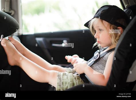 Male Toddler With Feet Up Staring In Back Seat Of Car Stock Photo Alamy