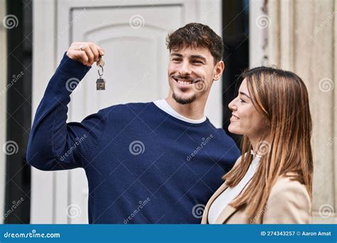 Mand And Woman Couple Hugging Each Other Holding Key Of New Home At