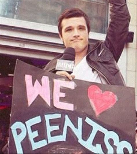 josh hutcherson posing with a sign of their couple name hunger games