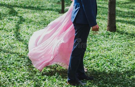 Wedding Couple Stands On Emerald Bright Green Grass In The Summer Park