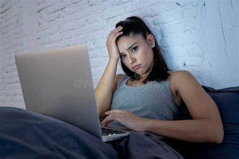 Pretty Latin Woman Bored And Addicted To Her Device In Bed Stock Image
