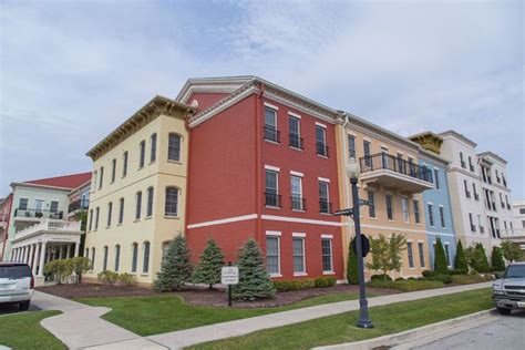 A Row Of Multi Story Buildings On The Corner Of A Street With Cars