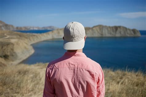 Premium Photo Young Man Standing On A Mountain Shore Looking To The Sea