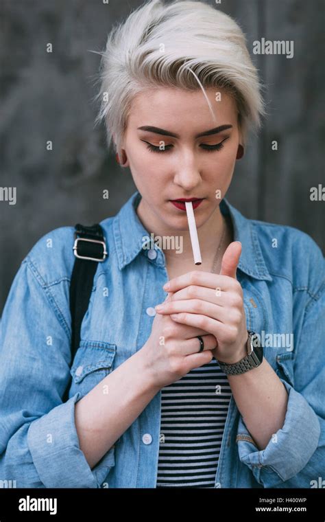 Young Fashionable Woman Smoking Cigarette While Standing Outdoors Stock