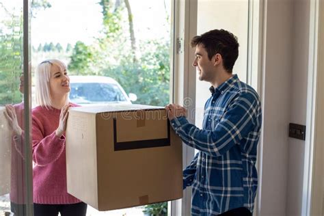 Young Couple Carrying Boxes Into New Home On Moving Day Stock Photo