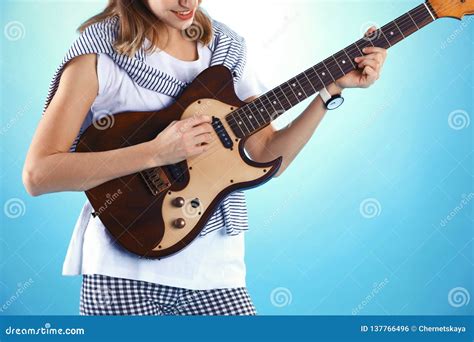 Young Woman Playing Electric Guitar On Color Background Stock Photo