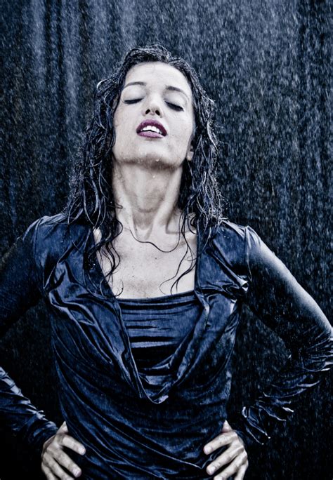a woman with her eyes closed standing in the rain