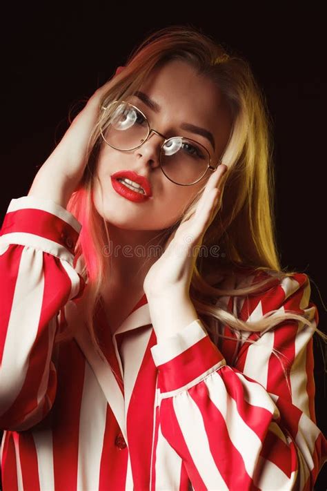 Attractive Blonde Girl In Glasses Wearing Striped Blouse Posing Stock