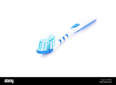 Close Up Shot Of A Toothpaste On A Blue Toothbrush Isolated On White