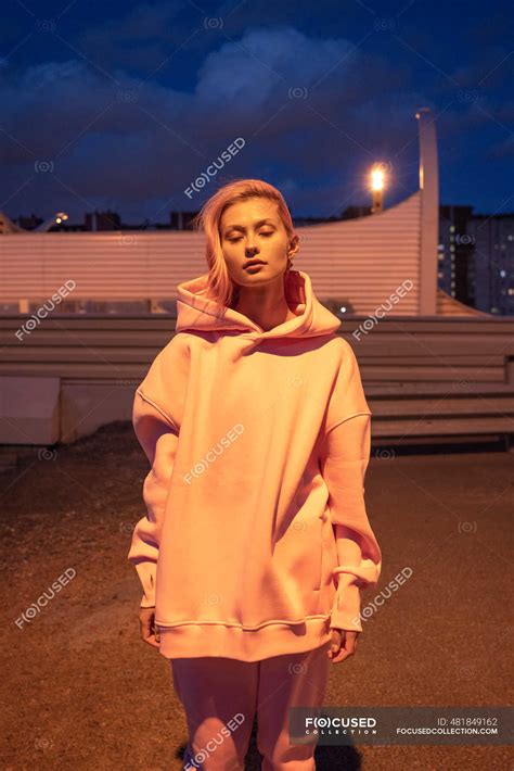 Portrait Of Young Woman With Pink Hair Wearing Track Suit Standing In