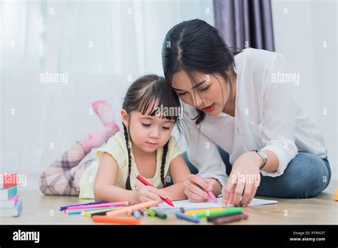 mom teaching her daughter to drawing in art class back to school and education concept