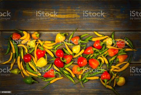 Different Types Of Hot Peppers On Wooden Background Stock Photo