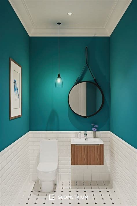 A White Toilet Sitting Next To A Bathroom Sink Under A Round Mirror On