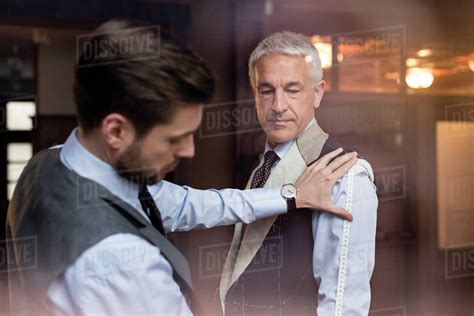 Tailor Fitting Businessman For Suit In Menswear Shop Stock Photo