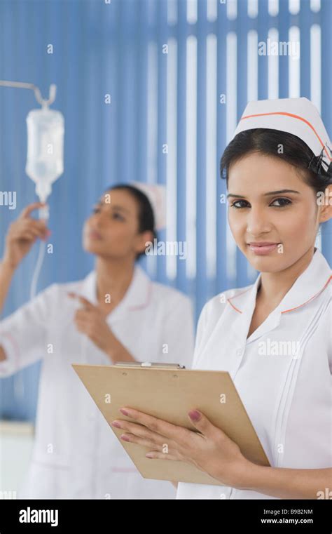 Two Female Nurses Adjusting A Saline Drip Stock Photo Alamy