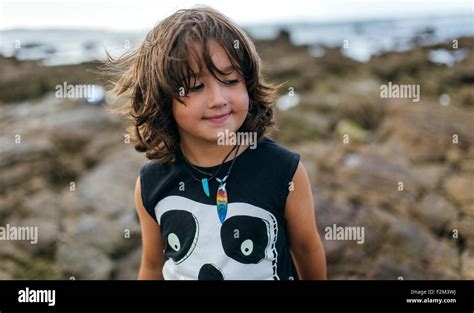 Spain Gijon Portrait Of Smiling Little Boy At Rocky Coast Stock Photo