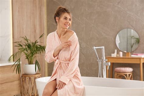 Beautiful Woman Sitting On Edge Of Tub In Bathroom Stock Image Image