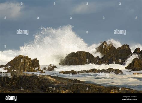 A Huge Wave Hitting Rocks On The Shore Stock Photo Alamy