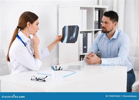 Orthopedist Showing X Ray Picture To Patient In Clinic Stock Image