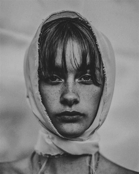 A Woman With Freckles On Her Face And Hood Over Her Head