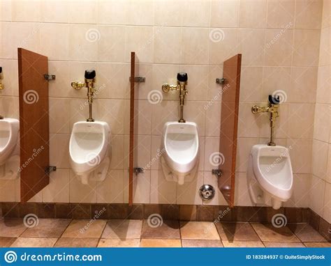 Urinal In Mens Public Restroom Bathroom With Luxury Gold Plumbing Stock