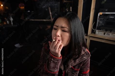 Asian Girl Smoking A Weed Joint Getting High Inhaling And Exhaling Weed