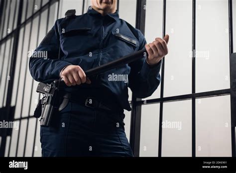 A Strict Prison Guard In Uniform Guards Cells With Prisoners In A
