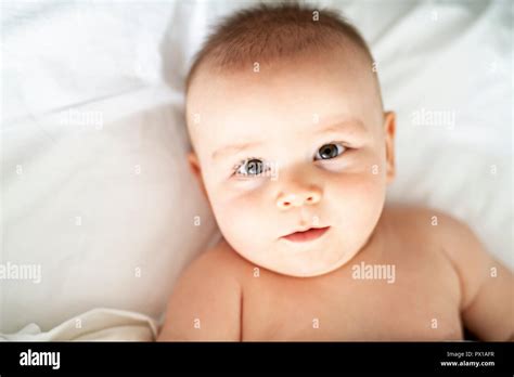 Happy Cute Baby Lying On White Sheet Stock Photo Alamy